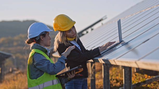 istock Female engineers working in solar power plant. Solar city. 1453678259