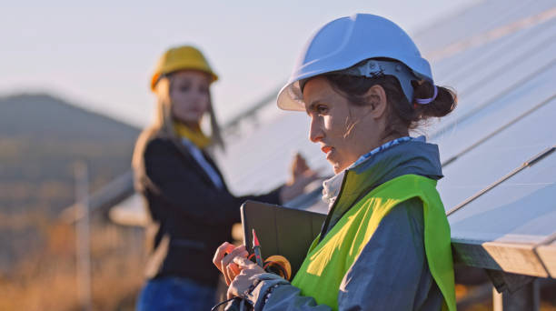 istock Female engineers working in solar power plant. Solar city. 1453678262