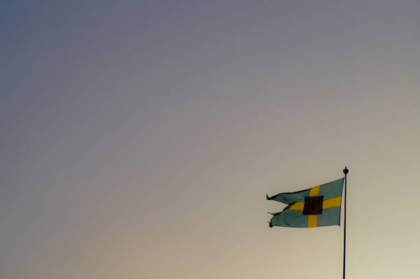 istock Low angle view of Swedish flag against sunset 1453680137