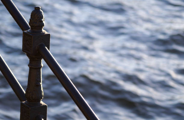 Close up of a iron handrail against water