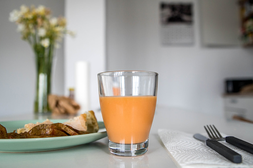 Picture of Tasty Glass of Salmorejo Cream Typical Spanish Dish with a Plate of Bread and Tomato on an Elegant Kitchen Table