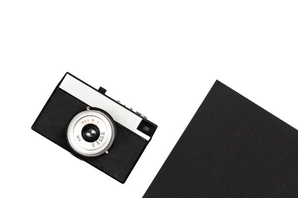 Old film camera on a black and white background, flat lay.