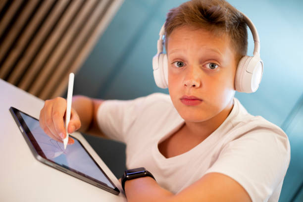 istock Teenage boy drawing on digital tablet 1453688893