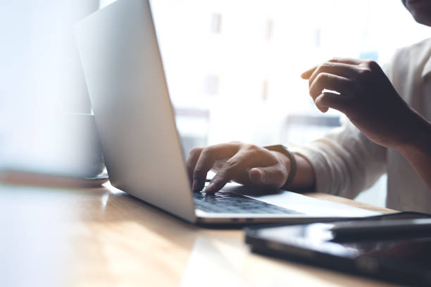 istock Business man busy working on laptop computer with digital tablet on office table. Blogger typing on laptop keyboard. Student studying online, E-learning, working at home, freelance work 1453688939