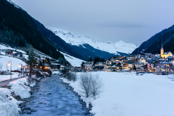 hermoso paisaje de ishcgl en austria con el río que fluye a través del complejo cubierto de nieve - ski resort austria village winter fotografías e imágenes de stock