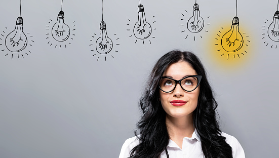 Idea light bulbs with young businesswoman in a thoughtful face