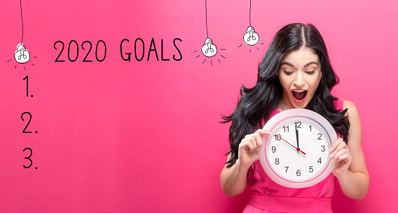 2020 goals with young woman holding a clock showing nearly 12