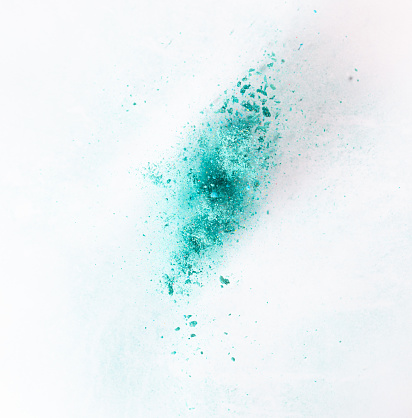 blue green yellow powder explode on pink background captured in high speed