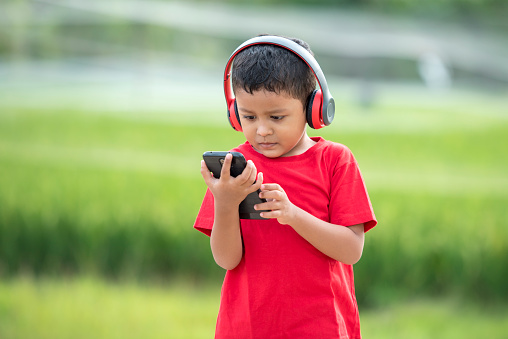 Toddler boy listening to music using headphones