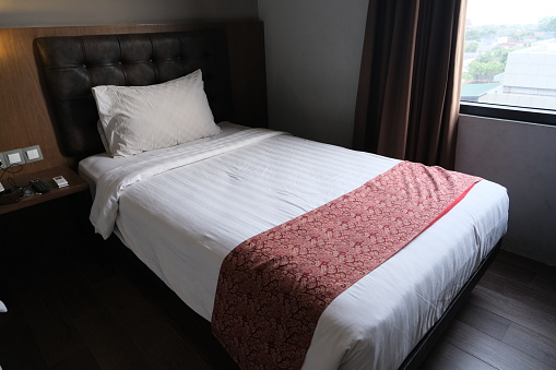 A clean tidy single bed in hotel room