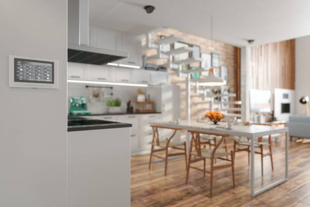istock Smart Home Control System On The Wall With Blurred Kitchen And Living Room Background 1453719109