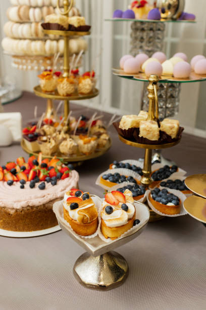istock Table with cakes, sweets, candy, buffet. Dessert table for a party goodies for the wedding banquet area. Close up candy bar. Decorated delicious. 1453722414