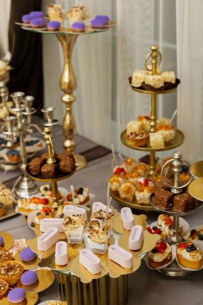 istock Table with cakes, sweets, candy, buffet. Dessert table for a party goodies for the wedding banquet area. Close up candy bar. Decorated delicious. 1453722428