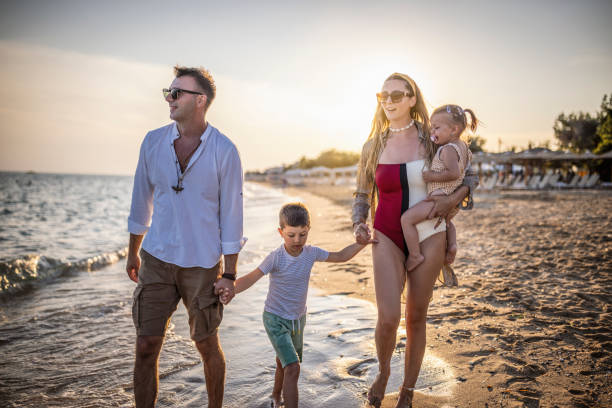 istock Family walking on the beach 1453723738