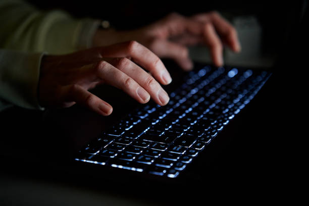 istock Typing on laptop keyboard at night, close up 1453725686