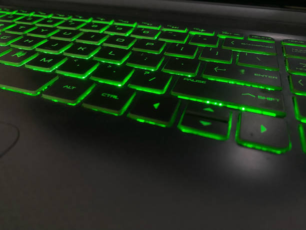istock illuminated keyboard or flashing keyboard. cool keyboard with its green light use in the dark. Dark mode 1453726013