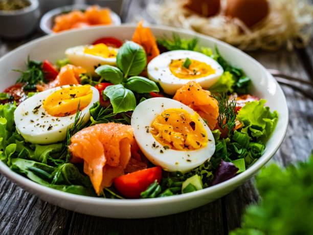 istock Smoked salmon with boiled eggs and leafy vegetables on wooden table 1453726562