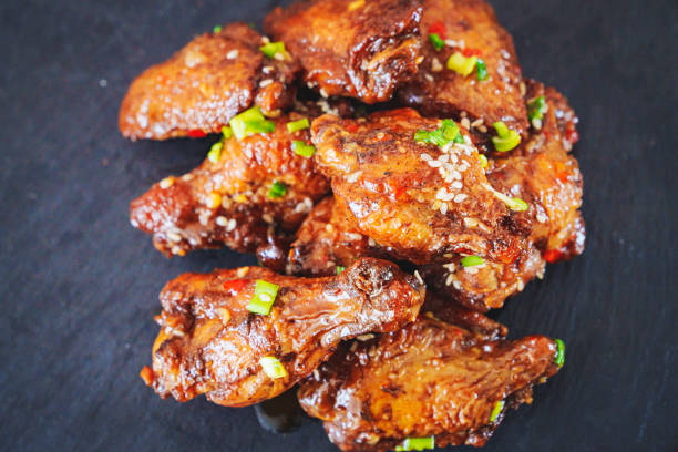 istock fried chicken with garlic and sesame in caramel on a black tray. 1453726580