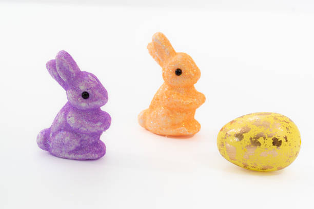 istock Two toy rabbits and a colorful Easter eggs isolated against a white background. 1453731538