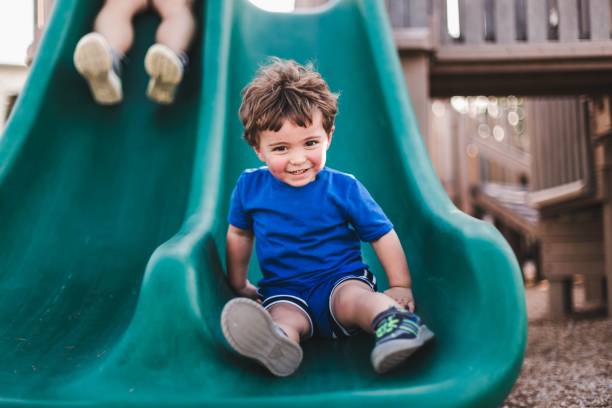 istock Caucasian boy feeling happy while sliding on the playground 1453733804