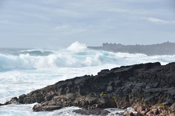 istock Waves crashing onto the rocks on the beach 1453733872