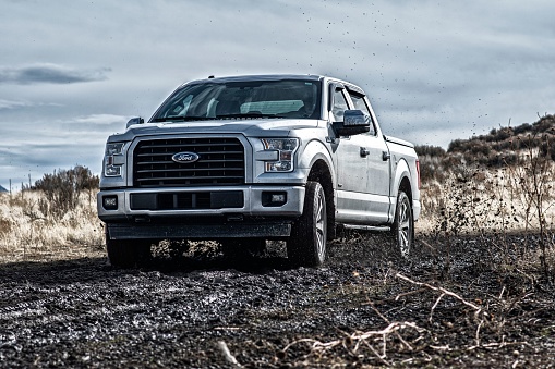 Provo, United States – October 15, 2022: The Ford F150 Silver Truck Car 4x4 SUV driving in the mud