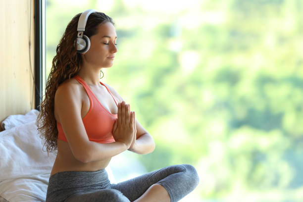 yogi con le cuffie ascolto audioguida yoga - the thinker audio foto e immagini stock