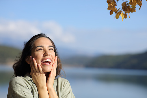 Surprised happy woman looking above in a lake