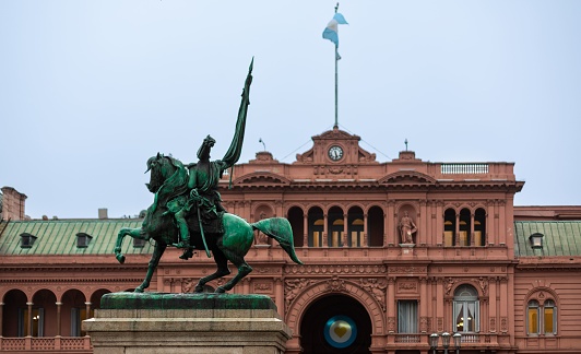 An exterior view of Casa Rosada with a statue in front Federal government office in Buenos Aires, Argentina