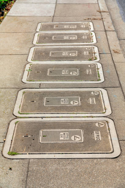 Looking down at an old concrete and metal manhole cover in a road.