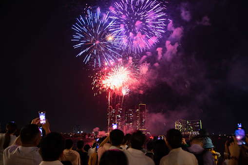 Ho Chi Minh City, Vietnam: People are watiching the Fireworks that light up the Saigon river with building background during New Year's Eve celebrations near Nguyenhue street, District 1 on December 31, 2023.