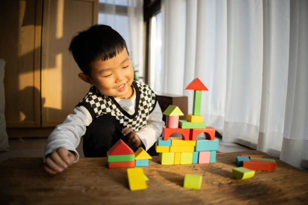 istock Little boy playing with colorful toy blocks 1453746051