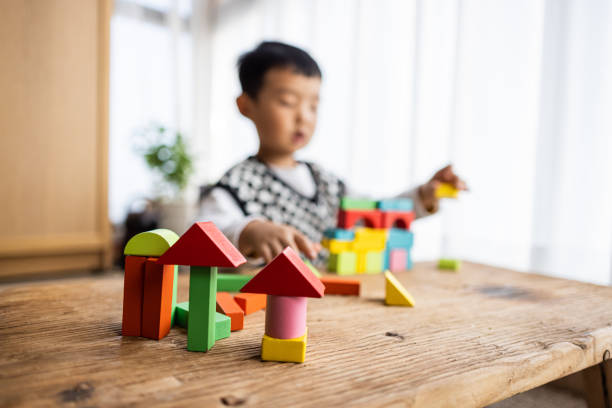 Little boy playing with colorful toy blocks