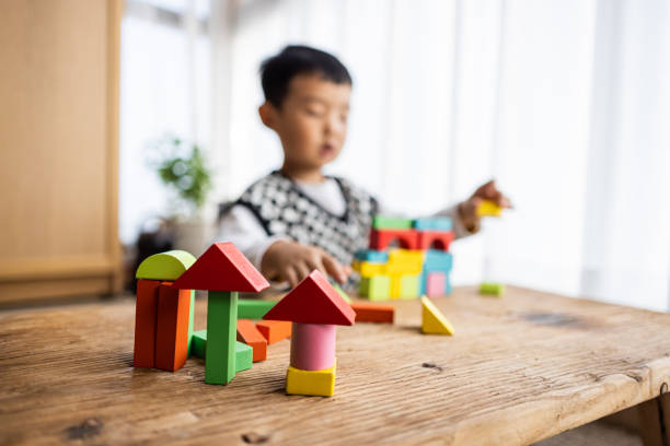 Little boy playing with colorful toy blocks stock photo