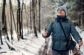 Mature man enjoying hiking in the forest on winter day