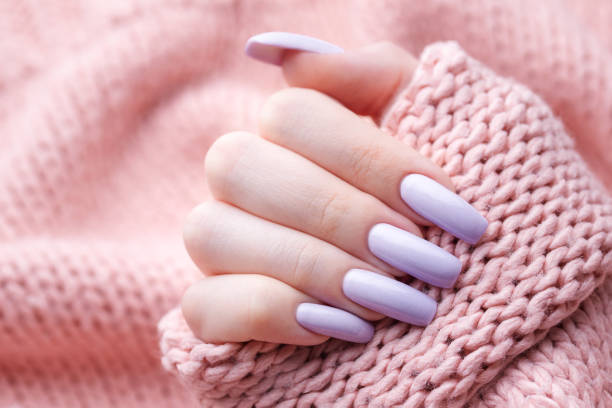 istock Girl's hands with a soft purple manicure. 1453754366