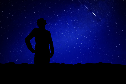 Man looking at the night sky, stars, planets and shooting stars.