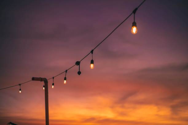 istock Image of a wire with light bulbs during a beautiful sunset 1453754823