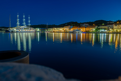 The beautiful Sali Harbor at night with a big boat. Colour of the town and light reflection on the sea