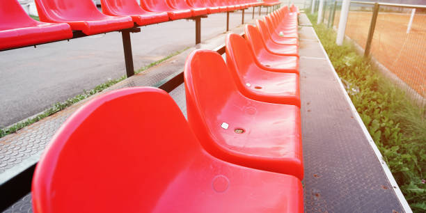 istock Row with empty red plastic seats on sportive playground outdoor 1453757186