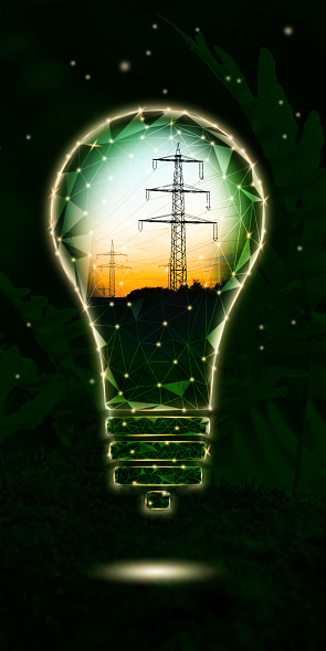 High-voltage power lines in a symbolic light bulb on a green background. Energy security. Low-poly design based on photography. Vertical
