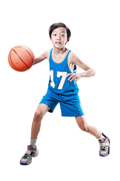 молодой мальчик играет в баскетбол изолированы на белом - basketball basketball player shoe sports clothing стоковые фото и изображения
