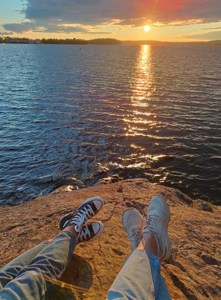 dos amigos viendo la puesta de sol - finland lake summer couple fotografías e imágenes de stock