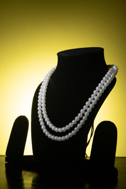 white pearl necklace on mannequin against yellow background, semi precious jewelry