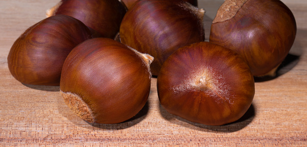 Group of chestnuts fresh from the tree for a background on a wood table