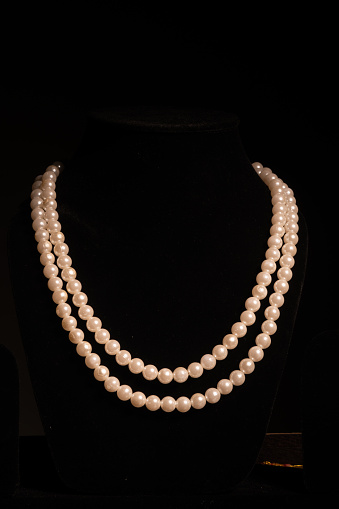 Pearl necklace on black background, white pearl jewellery