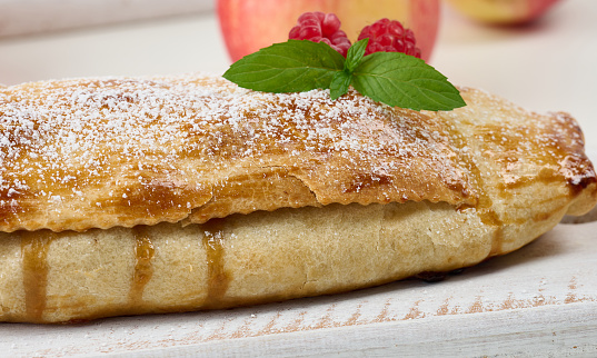 Roll pie with cheese. Turkish tepsi boregi, round borek, pastry (Turkish name; rulo borek). In a baking tray on a dark background