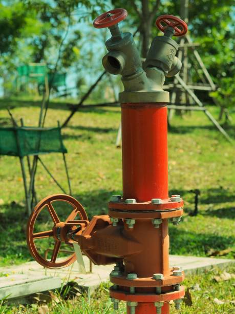 istock Red water spout on green grass and trees and silver blue sky roof. 1453765150