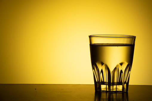 Water glass on yellow background