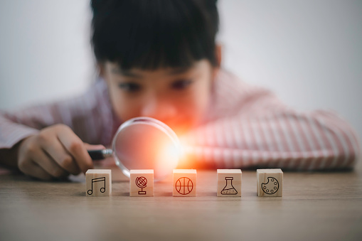 Asian smart kids girl using a magnifying glass to explore..skills to become geniuses. Number, Language, Motor Skill, Creative Thinking,